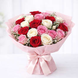 Bouquet of red, pink, and white roses wrapped in pink paper