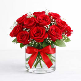Red roses in a glass vase with a red ribbon
