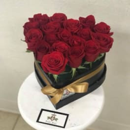 Heart-shaped box of red roses with a gold ribbon