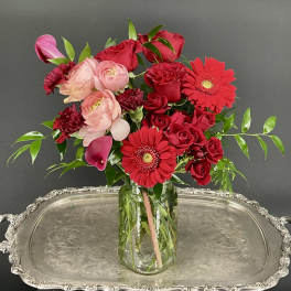 Red and pink flower arrangement in a clear glass vase