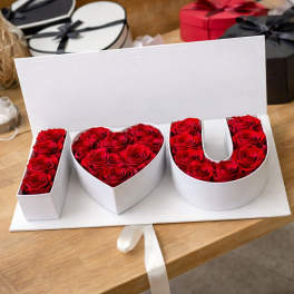 Red roses arranged in a white box spelling I heart U