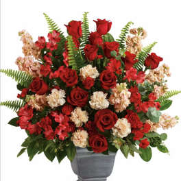 Red roses and red carnations in a gray urn vase