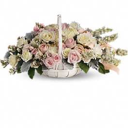 Basket arrangement of pink and white roses with a handle