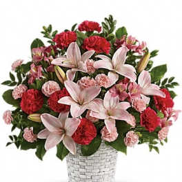 Pink lilies and red carnations in a white woven basket