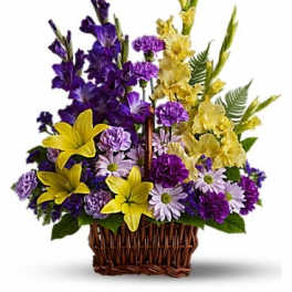 Purple and yellow floral arrangement in a wicker basket