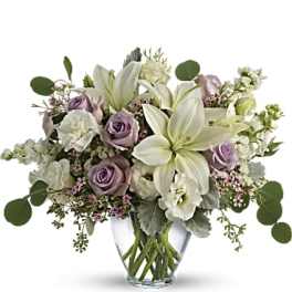 Lavender roses and white lilies in a clear glass vase