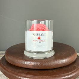 Glass Peony Garden candle with pink wax flower on a wooden stand