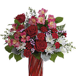 Red roses and pink alstroemeria in a red glass vase