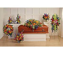 Colorful funeral casket spray with standing floral tributes