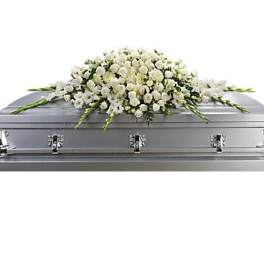 White floral casket spray on a silver casket