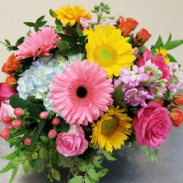 Mixed bouquet with pink gerbera daisies, yellow daisies, roses, and hydrangea
