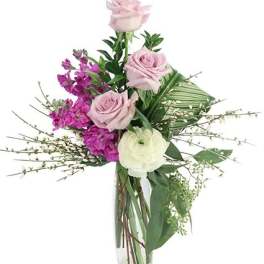 Pink roses and purple flowers in a clear glass vase