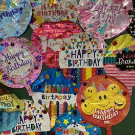 Assorted birthday balloons with colorful printed designs and messages