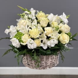 White and cream floral arrangement in a wicker basket
