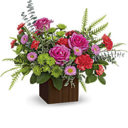 Mixed pink and red flowers in a wooden cube vase
