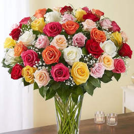 Mixed roses in a clear glass vase with baby's breath