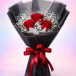 Bouquet of red roses with white baby's breath in black wrap and red ribbon