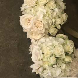 White rose and hydrangea floral garland on a dark surface