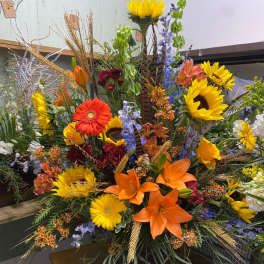 Large mixed floral arrangement with sunflowers, lilies, and gerbera daisies