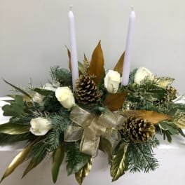 Holiday centerpiece with white roses, pinecones, and two white candles