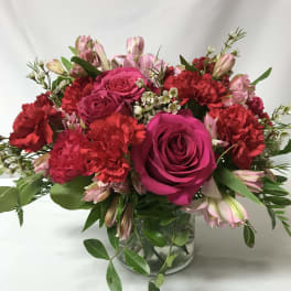 Bouquet of pink roses and red carnations in a glass vase