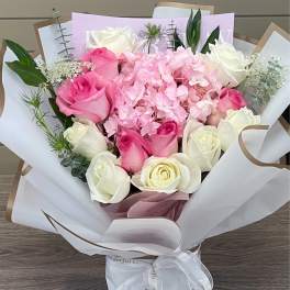 Pink and white rose bouquet with hydrangea in white wrapping