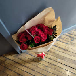 Bouquet of red roses wrapped in brown paper with a red ribbon