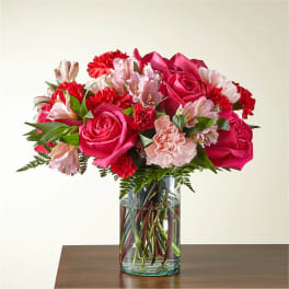 Pink roses and carnations in a clear glass vase
