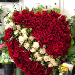 Heart-shaped arrangement of red and white roses on a stand