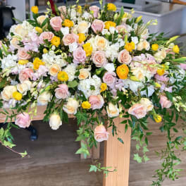 Large pastel floral arrangement with roses, ranunculus, and white blooms