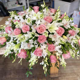 Pink roses and white orchids arranged in a low bouquet.