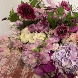 Large bouquet of pink, purple, and white flowers with green foliage