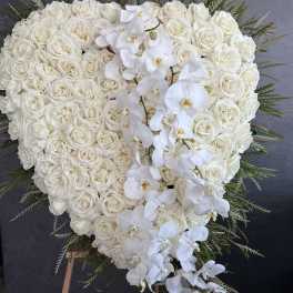 Heart-shaped white rose and orchid standing spray on an easel