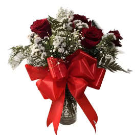 Red roses and white baby's breath in a glass vase with a large red bow