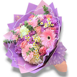 Pink and purple bouquet with roses and daisy-like flowers wrapped in purple paper