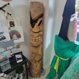 Tall carved wooden totem sculpture in a shop display