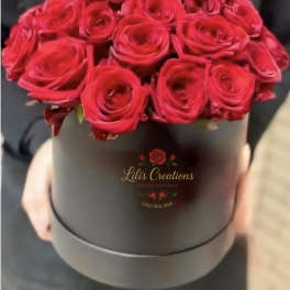 Red roses arranged in a black round box