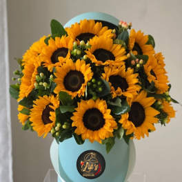 Bouquet of yellow sunflowers in a light blue hat box