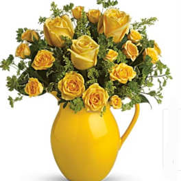 Yellow roses arranged in a yellow pitcher vase