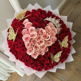 Heart-shaped bouquet of red and pink roses with gold butterfly picks