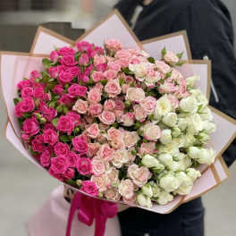 Large bouquet of pink, blush, and white roses wrapped in paper