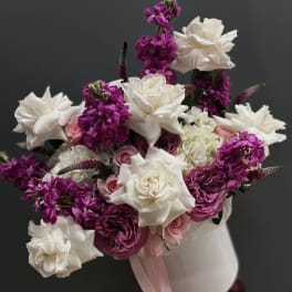 Bouquet of white and magenta flowers with pink roses in a white vase