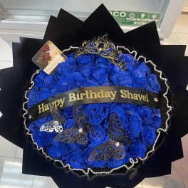 Blue rose bouquet with a birthday ribbon and decorative butterflies