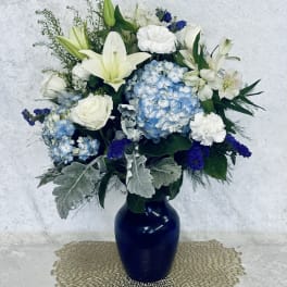 Blue and white floral arrangement in a dark vase