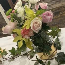 Pink roses and white daisies in a vase with ivy