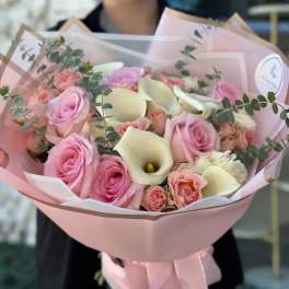 Bouquet of pink roses and white calla lilies wrapped in pink paper