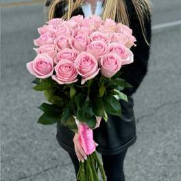 Handheld bouquet of pink roses with a pink ribbon wrap