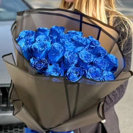 Bouquet of bright blue roses wrapped in brown paper