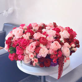 Large pink and red rose arrangement on a round table