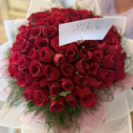Large bouquet of red roses wrapped in white paper